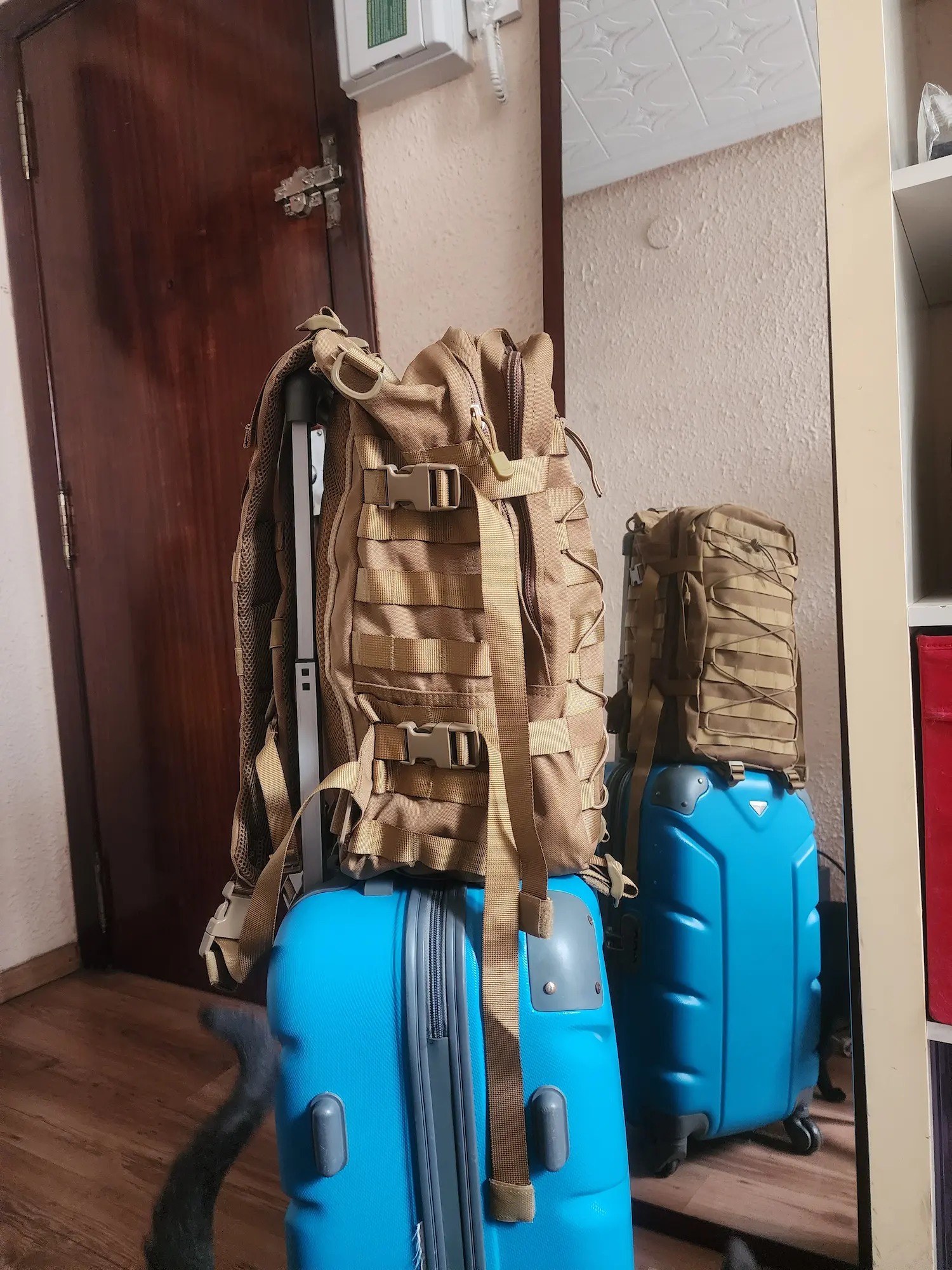 Maleta y mochila preparadas junto a la puerta de casa, listas para un viaje