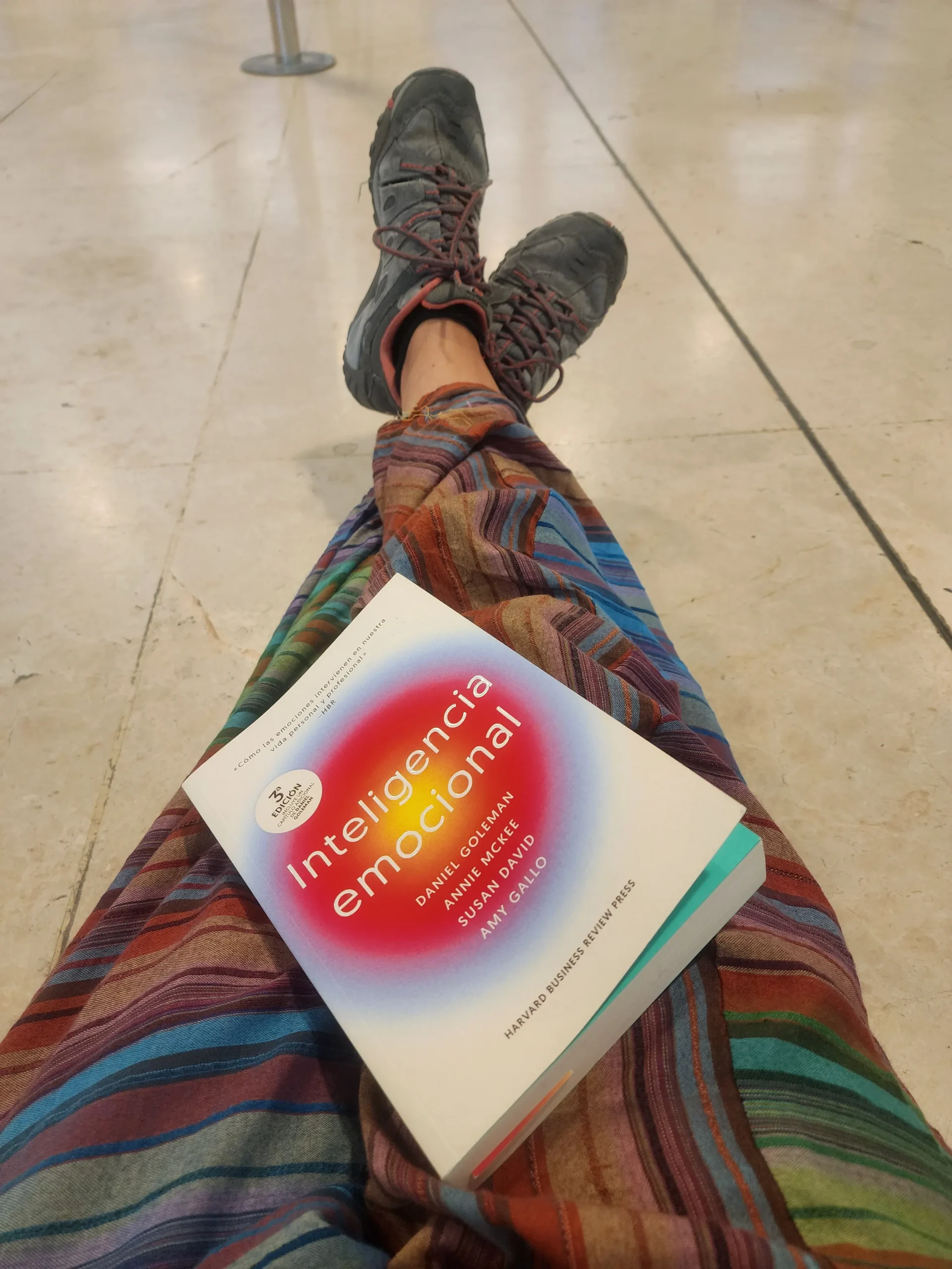 Rakel esperando en el aeropuerto con un libro antes de volar a Asia