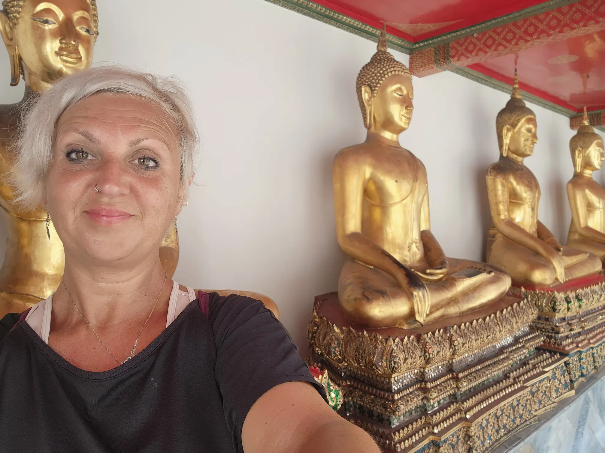 Hilo en la muñeca de Tailandia — fila de budas en un templo de Bangkok