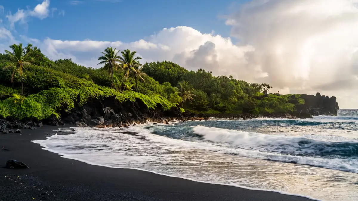 Playa de arena negra volcánica en la costa de Bali