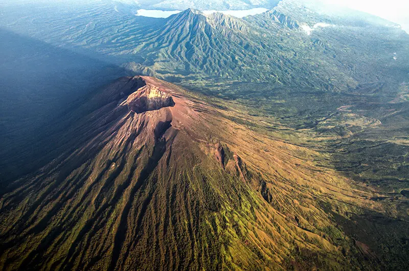 El volcán Agung de Bali emergiendo entre nubes al amanecer