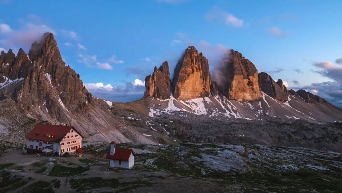 Paredes verticales de los Dolomitas con luz cálida al amanecer, en los Alpes italianos