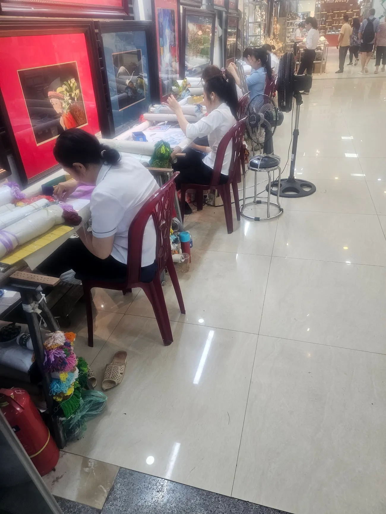 Trabajadoras vietnamitas cosiendo cuadros bordados a mano