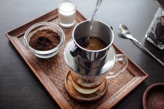 Café de Asia — filtro phin vietnamita goteando café sobre una taza