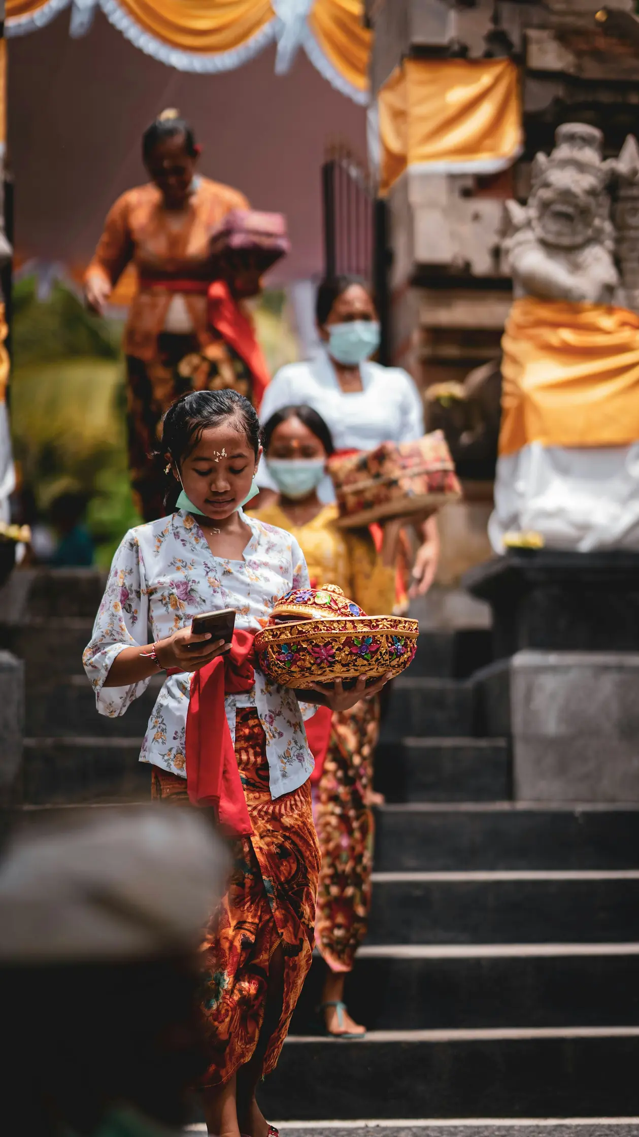 Mujeres balinesas bajando las escaleras de un templo con ofrendas