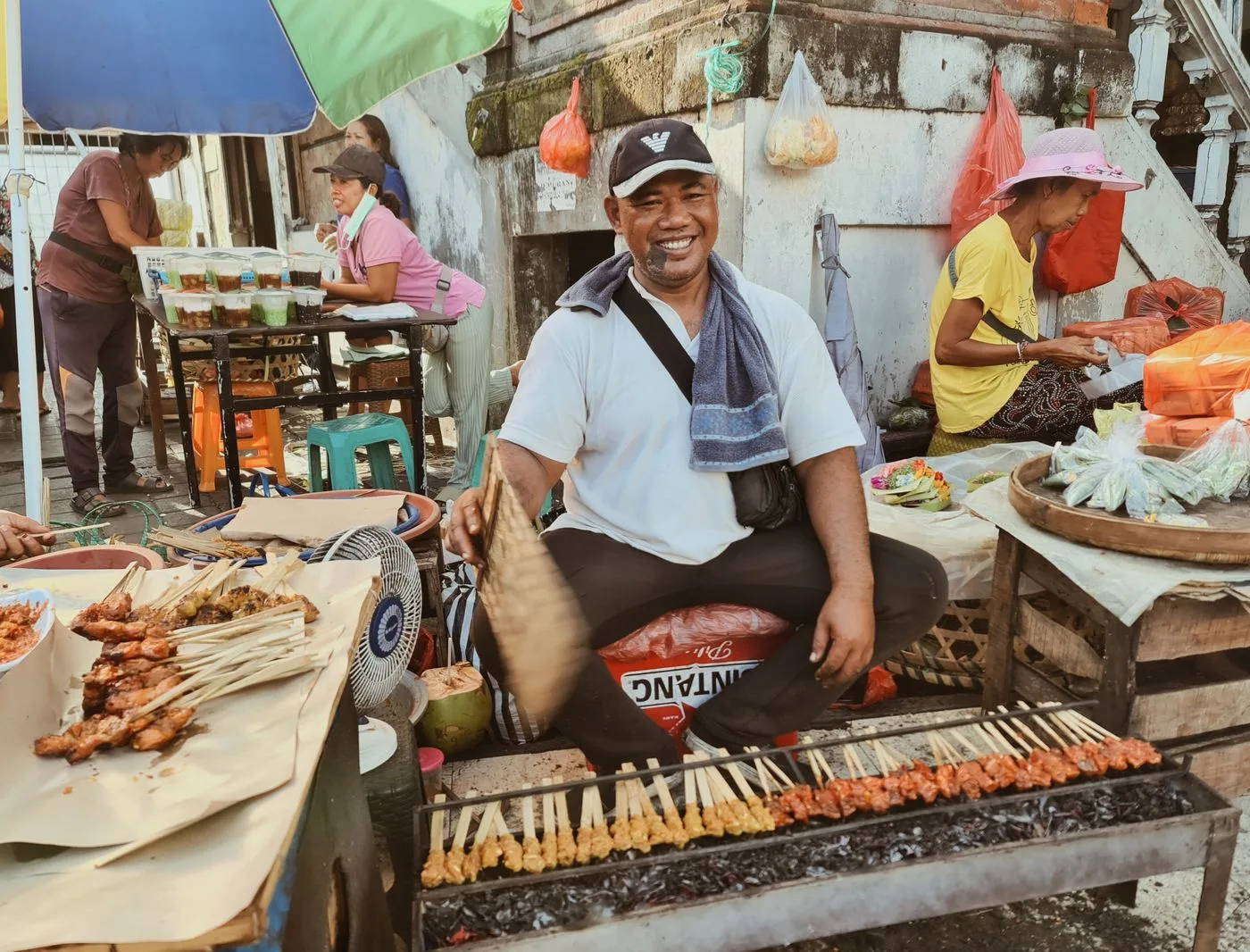 Vendedor asando sate en un mercado de comida de Bali
