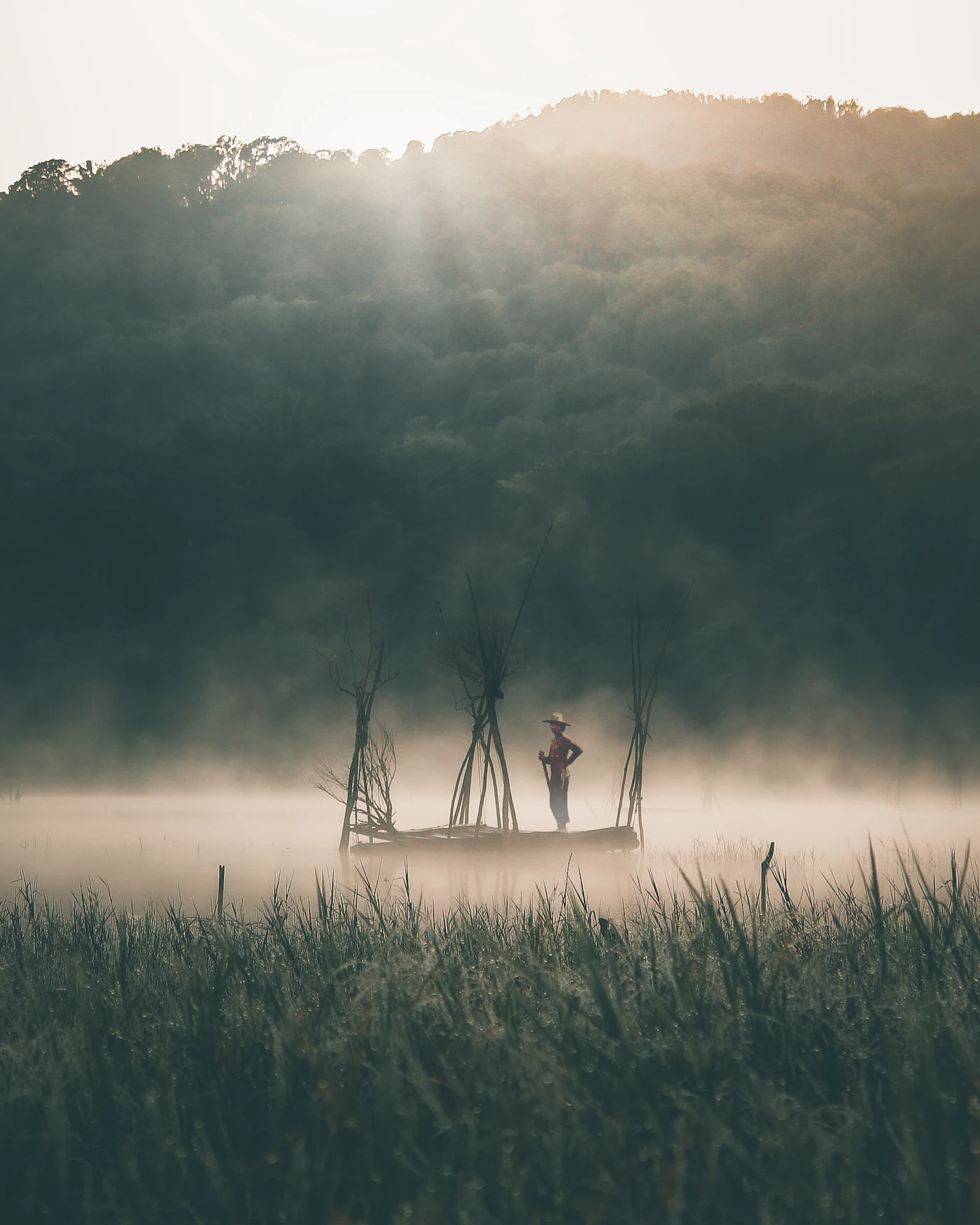 Pescador en el lago Tamblingan, cerca de Munduk, entre la niebla de la mañana